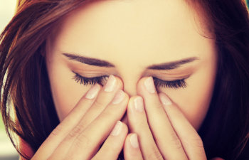 woman hides face in hands